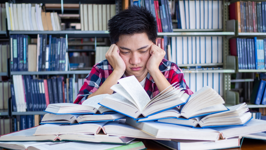 Asian Male Student Tired and Stressed with Readings